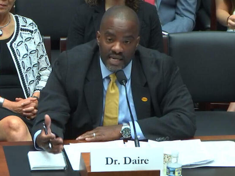 Daire sitting behind desk, speaking to U.S. House of Representatives