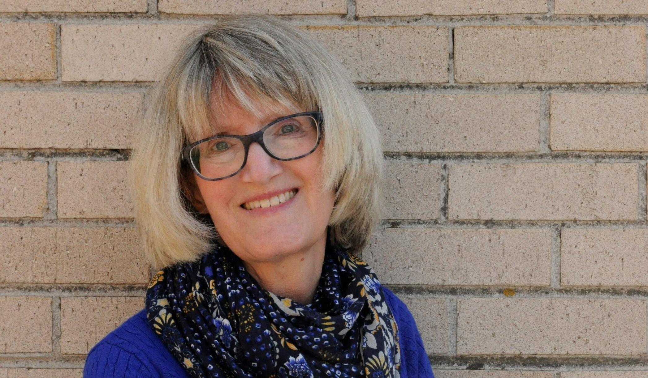 A portait of a woman with short hair and glasses. 