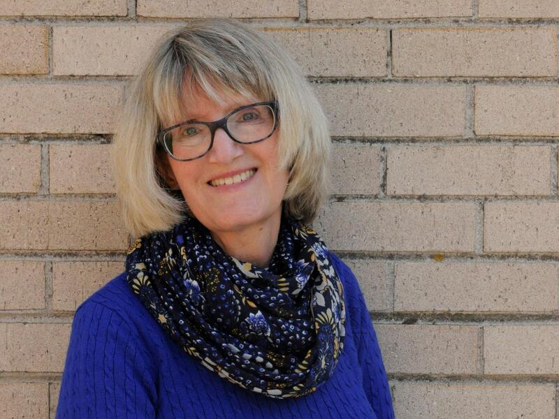 A portait of a woman with short hair and glasses. 
