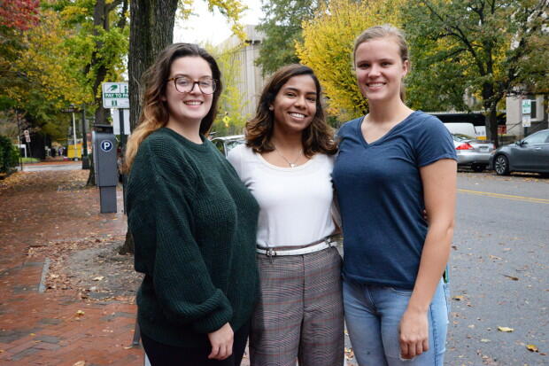 Three women stand.