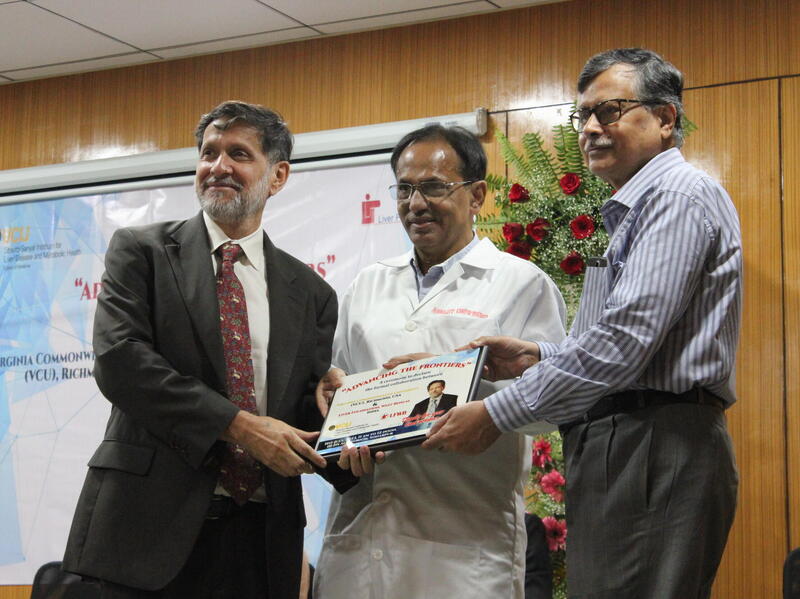 A photo of three men holding a piece of paper