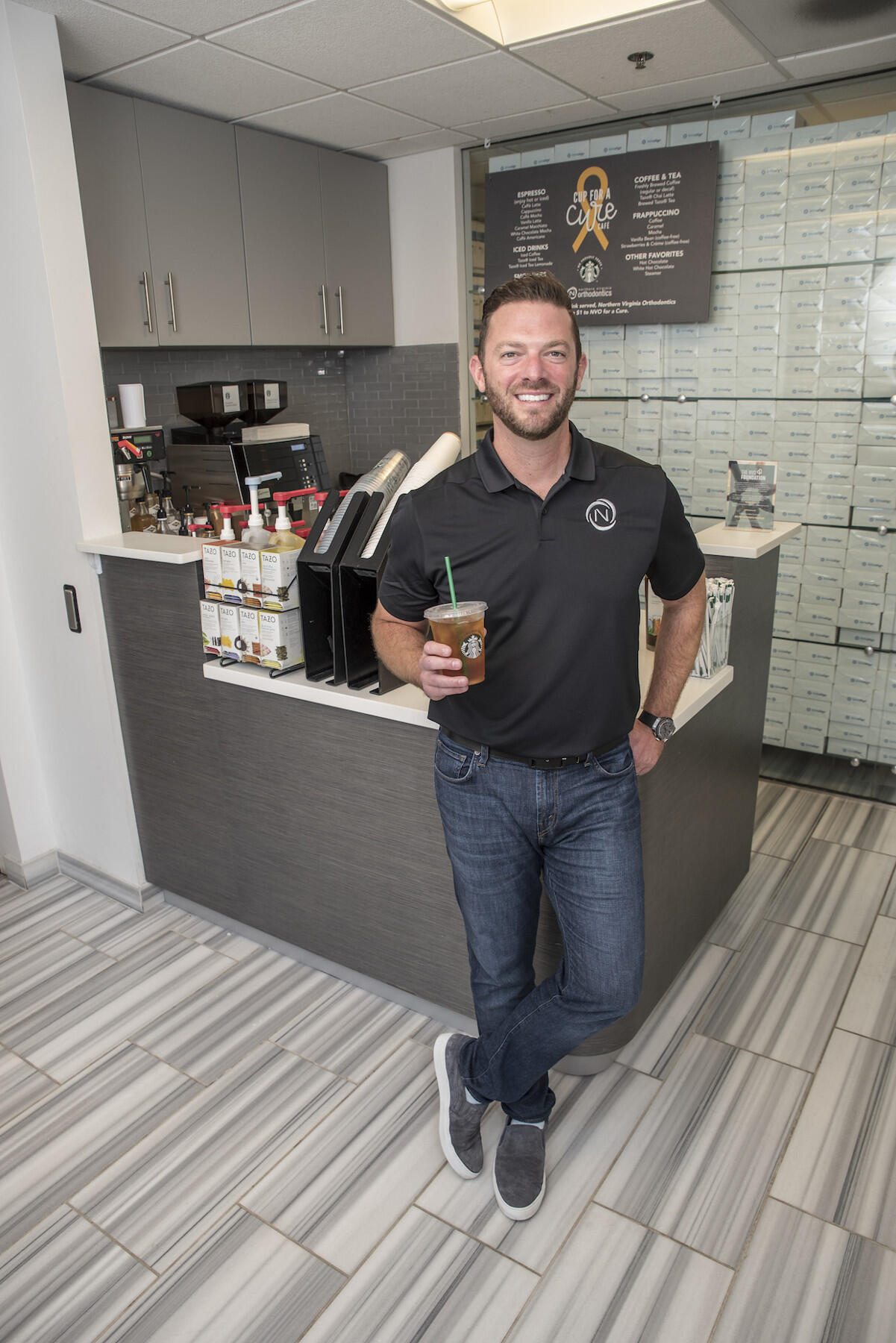 Man standing and holding cup.