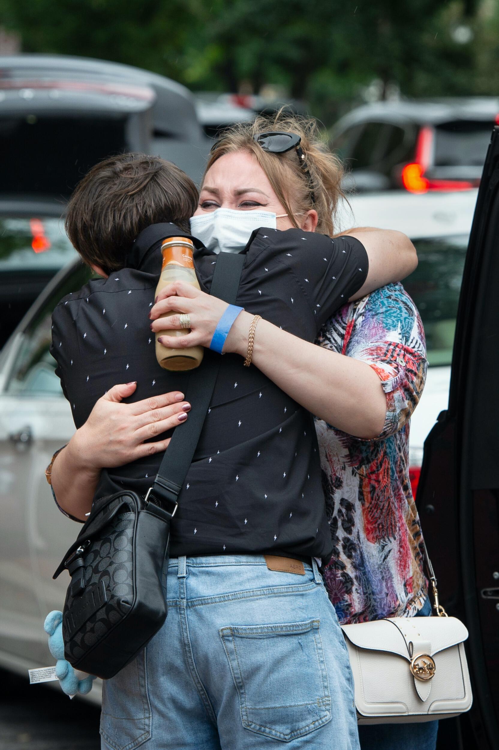 Elvira Walker (facing camera) gives a farewell embrace to her son, freshman Rahim Choudary, in front of Brandt and Rhodes halls.