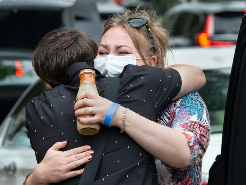 Elvira Walker (facing camera) gives a farewell embrace to her son, freshman Rahim Choudary, in front of Brandt and Rhodes halls.