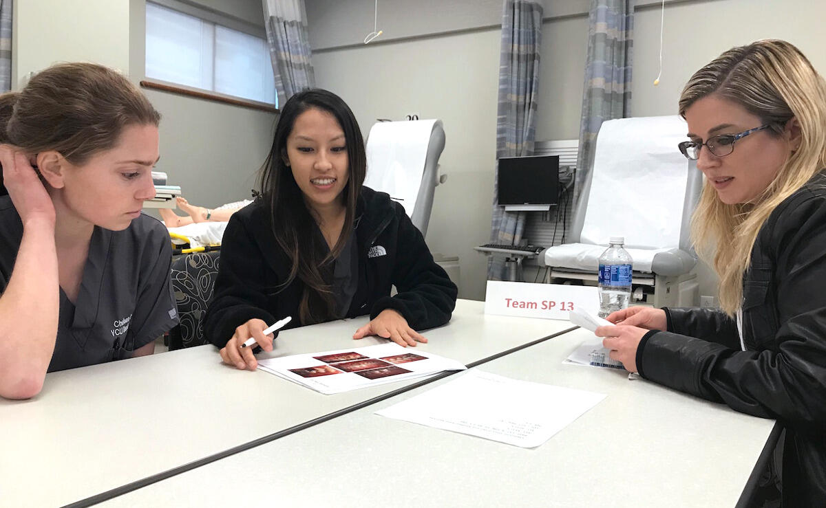VCU students Chelsea Tolbert, Carol Farn and Kristine Timerson review a case file.