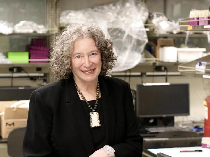 A photo of a woman sitting in a research lab. 