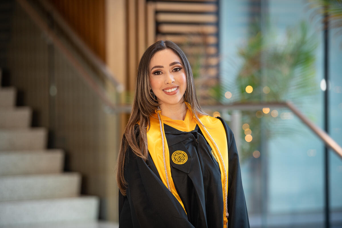 A portait of a woman wearing a graduation gown. 