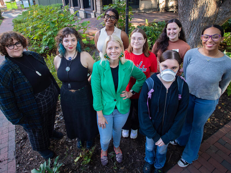 Eight people are lined up, looking slightly upward.