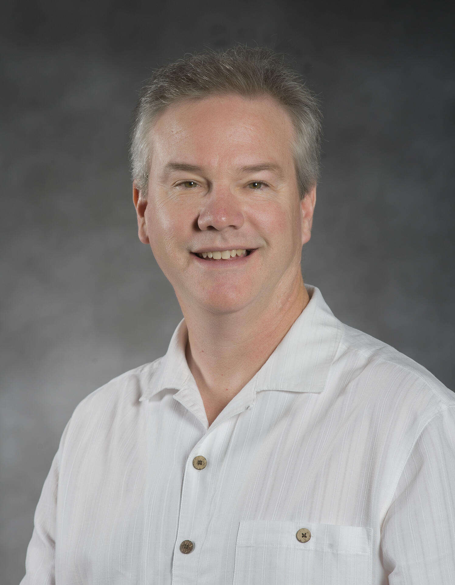 A photo of a man wearing a white button-down shirt. 