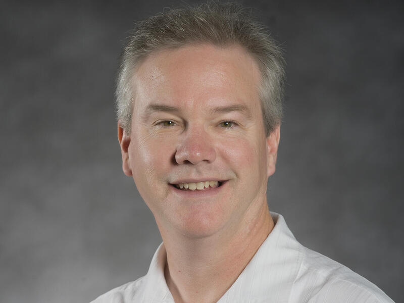 A photo of a man wearing a white button-down shirt. 