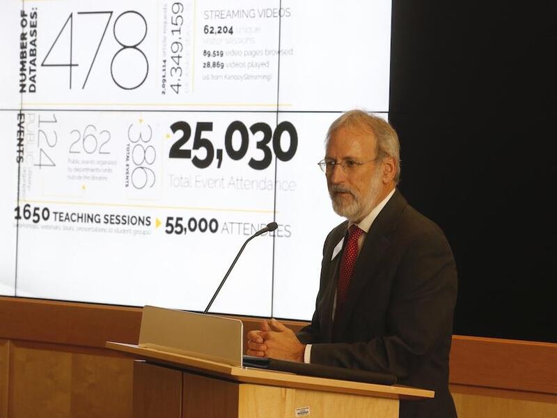 Man at podium in front of presentation. 