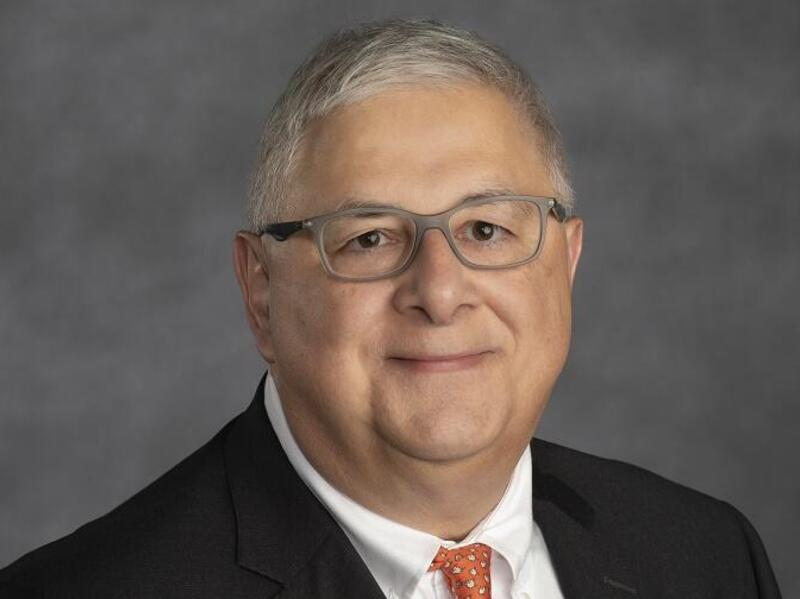 A headshot of a man wearing glasses 