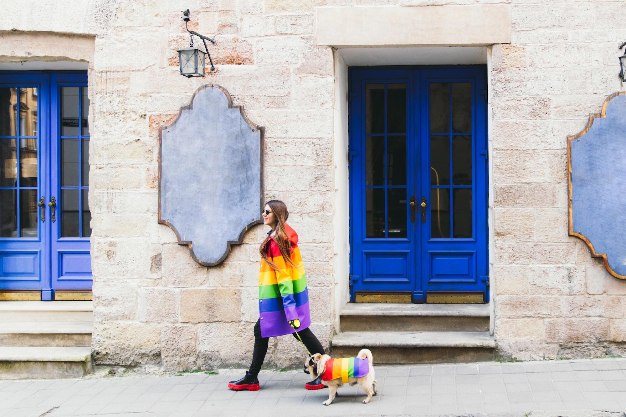 woman walking a dog. both are wearing pride clothing