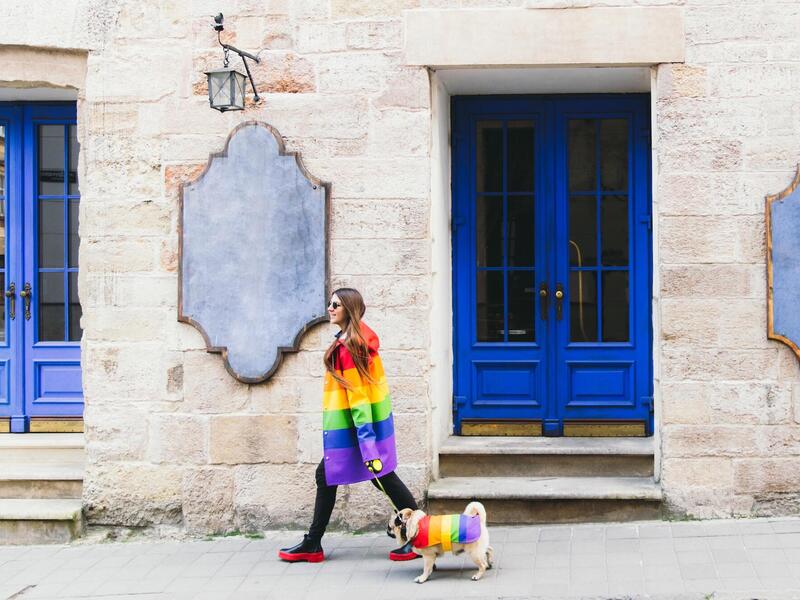 woman walking a dog. both are wearing pride clothing