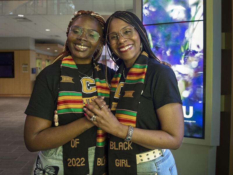 (left to right) Raeven and Felicia Smith holding hands and leaning their heads against each other while looking at the camera