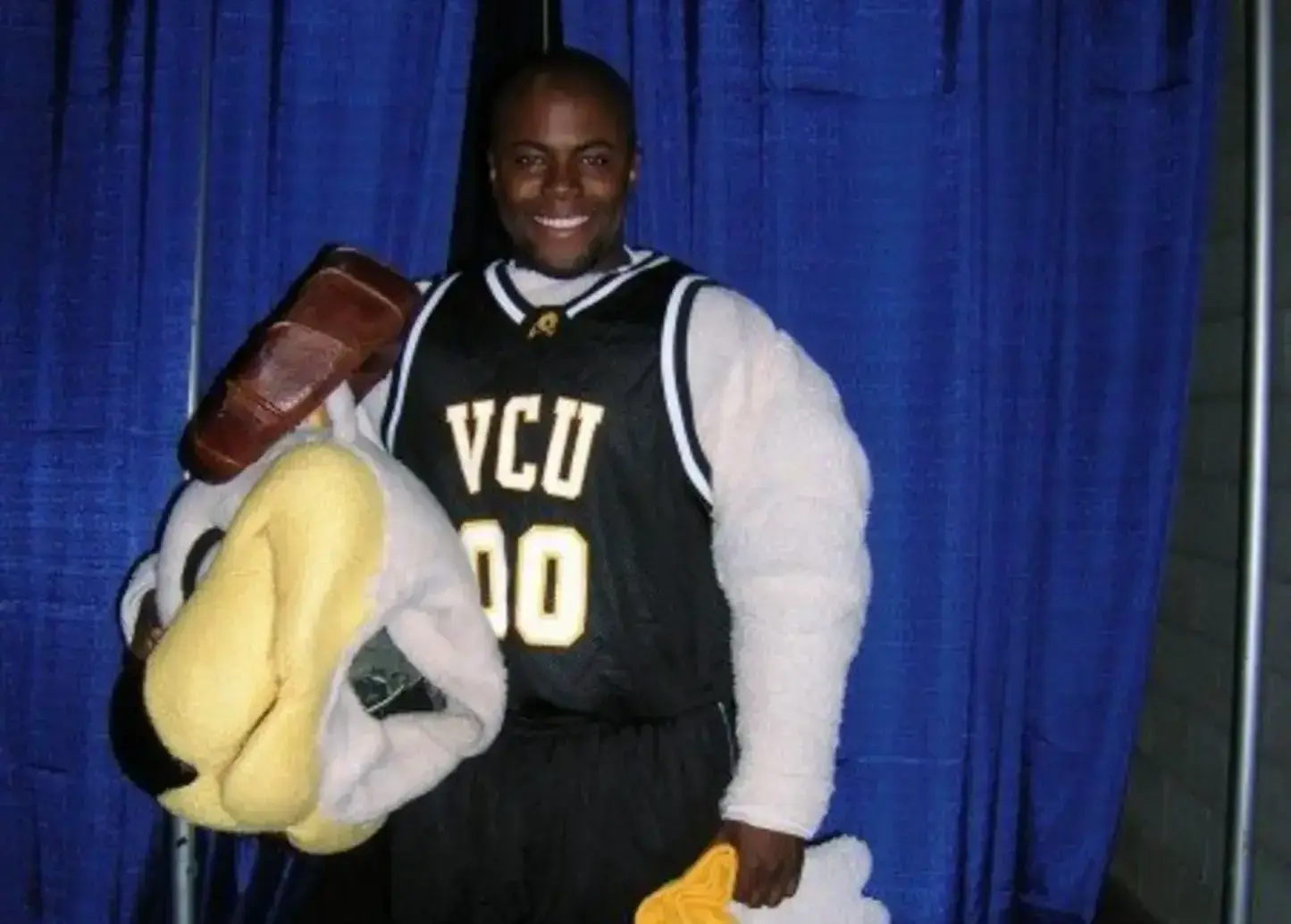 A man wearing a Rodney the Ram mascot costume with the mask off 