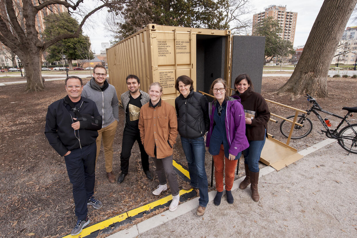 Manning (in purple jacket) and a group of Shared Studios staff and volunteers, stand outside the portal in Monroe Park.