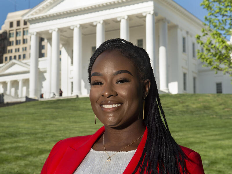 Whitney Brown smiling standing in front of the Virginia State Capitol 