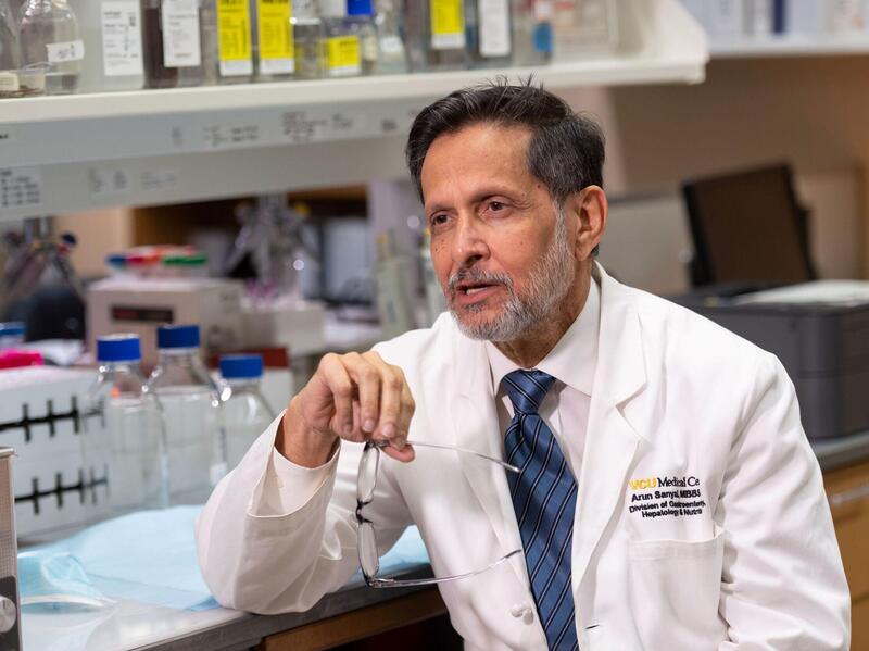 Arun Sanyal in a lab coat talking.