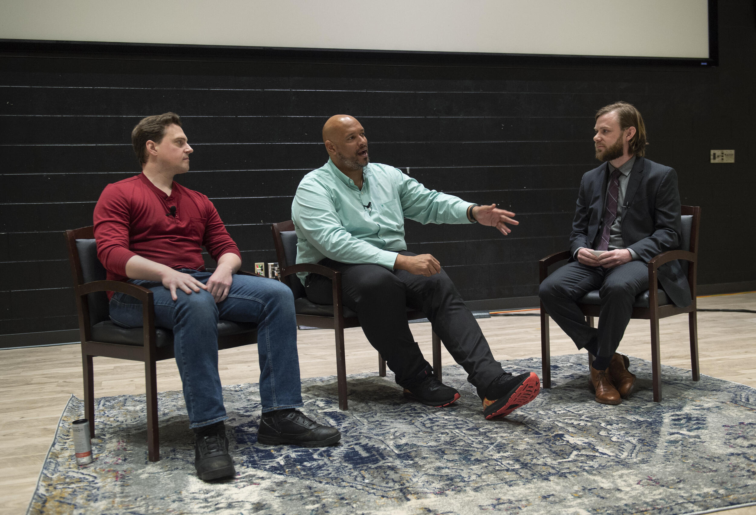 Three men sitting in chairs