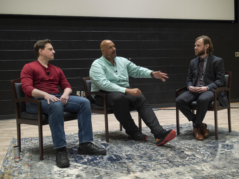 Three men sitting in chairs