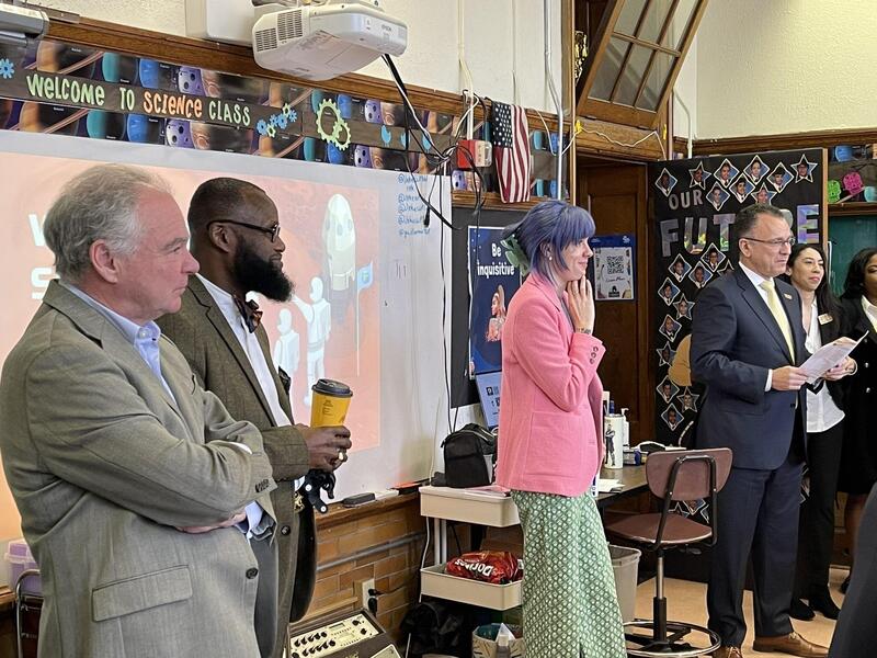 Five people standing at the front of a classroom. 