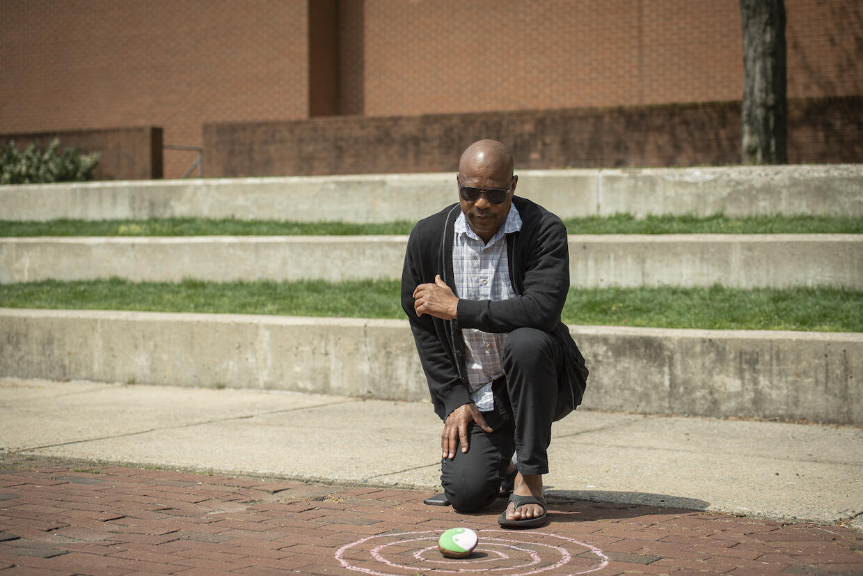 Dingani Mthethwa crouching on the ground in meditation
