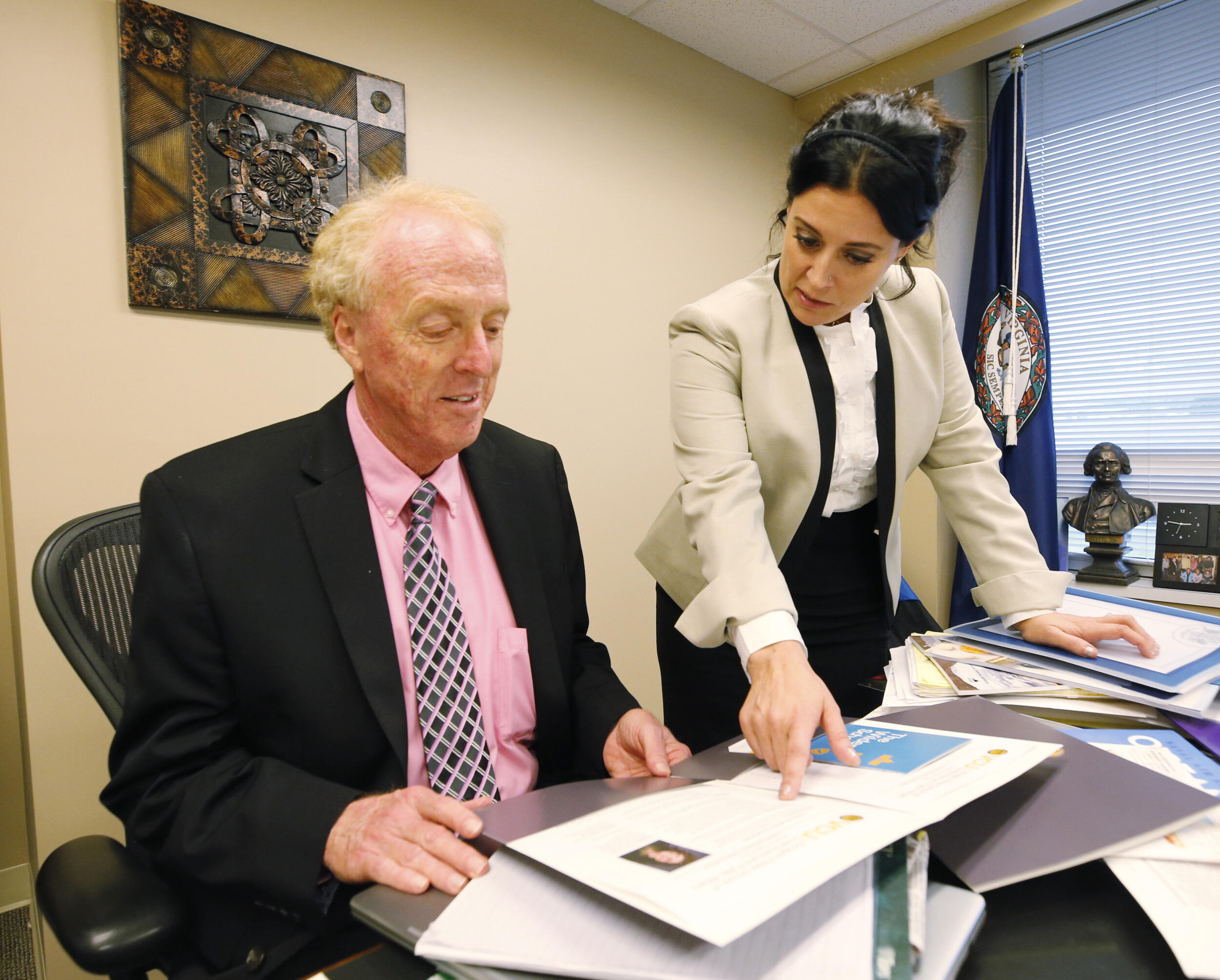 Two people reviewing a document at a desk.