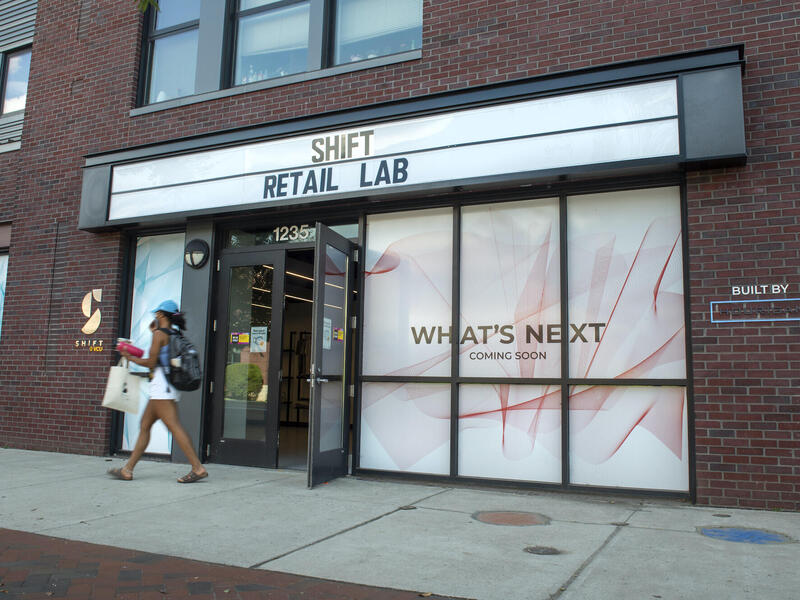 A photo of a woman walking past the Shift Retail Lab. 