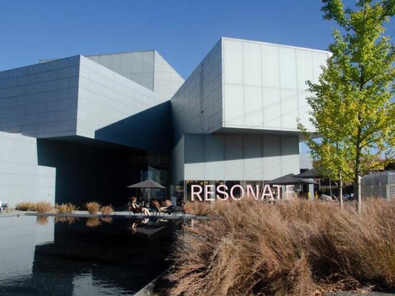 A picture of the Institute for Contemporary Art with the word \"RESONATE\" written across the bottom level's window in pink letters. 