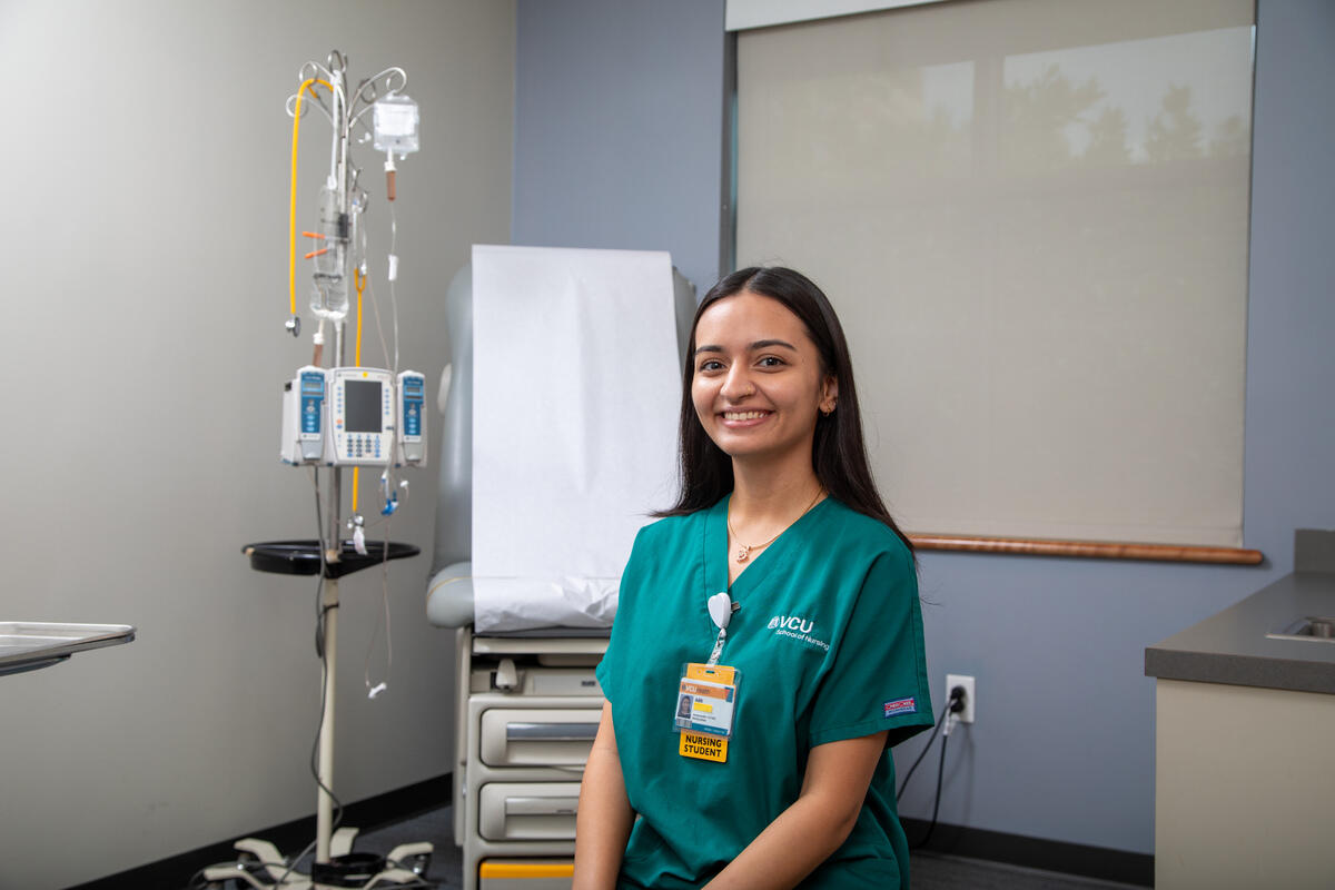 A woman wearing green scrubs standing in an examination room