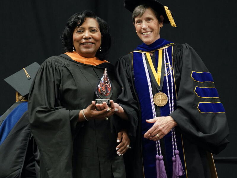 Linda Hines (left) receives the the Paul A. and Veronica H. Gross Achievement in Nursing Award from Jean Giddens, Ph.D., dean and professor at VCU School of Nursing, during the School of Nursing's commencement ceremony.