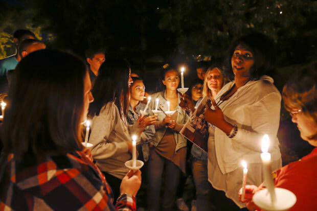 Egunfemi leads Wilder School students in a candle lighting ceremony to honor the lives of the enslaved at Richmond's African Ancestral Burial Grounds. 