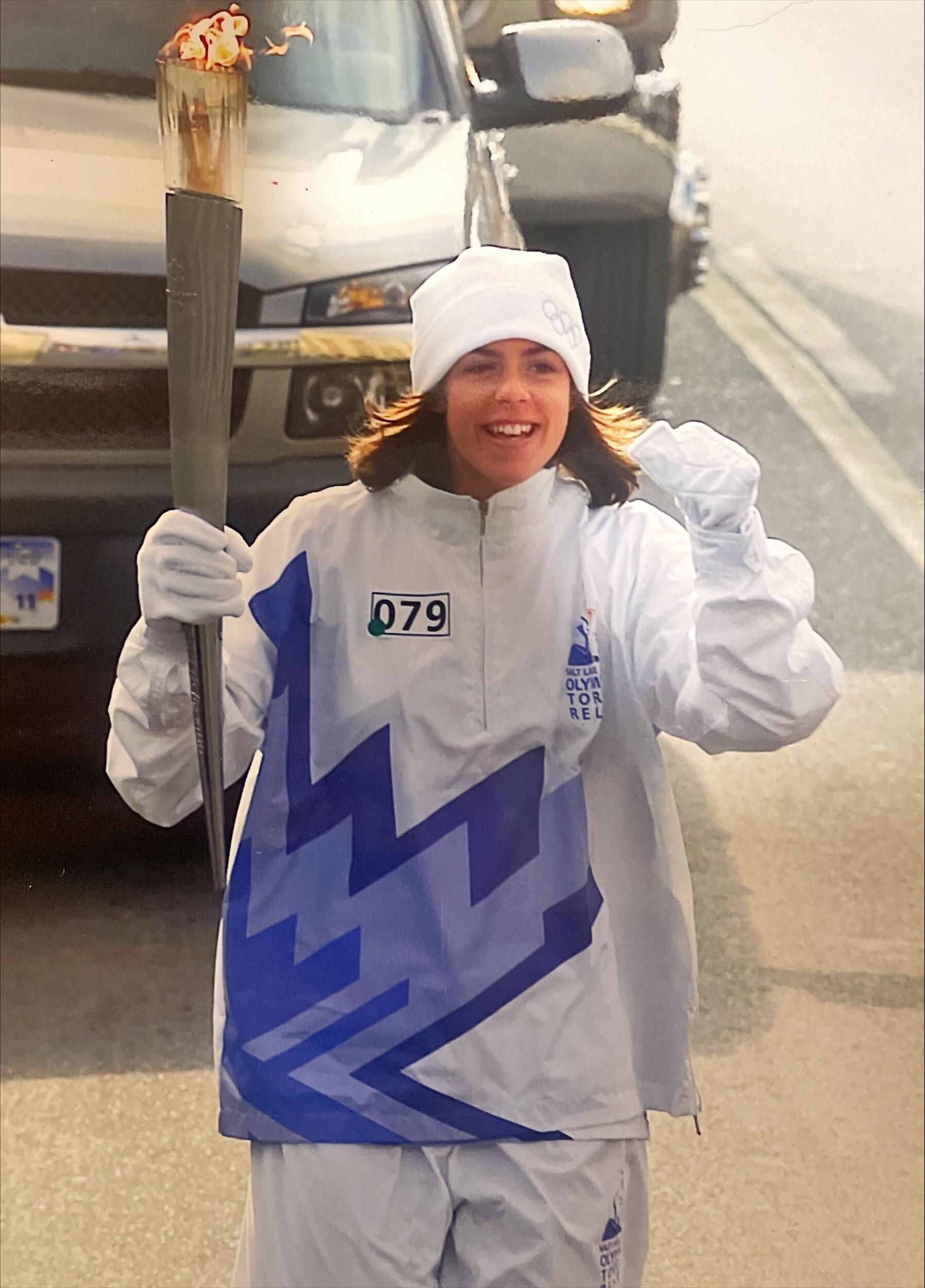 A photo of a woman carrying the olympic torch. 