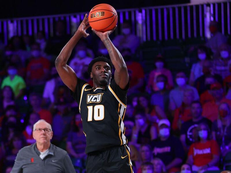 A man jumping up getting ready to shoot a basketball 