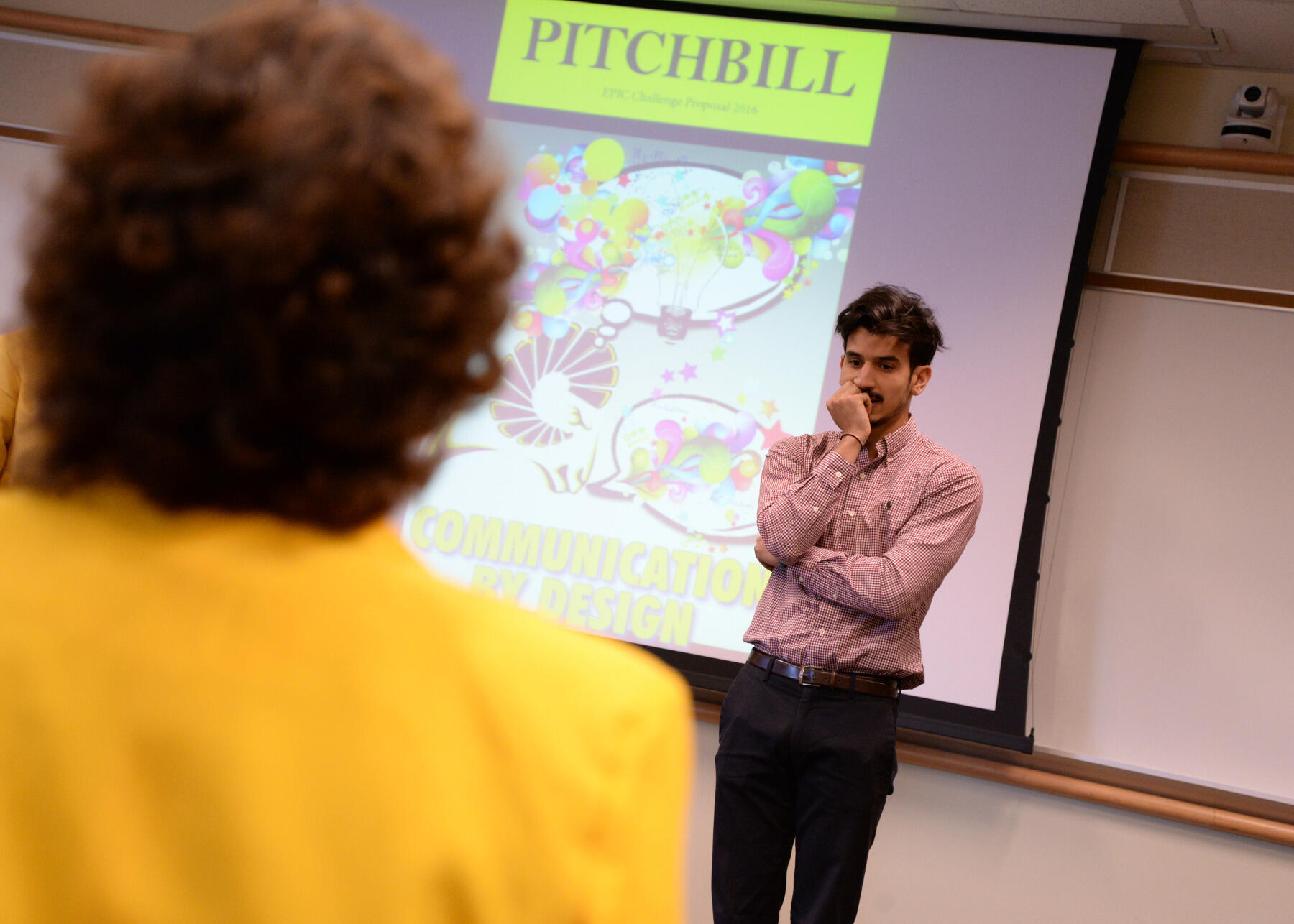 A student member of the Communication by Design team intentionally models poor body language and lack of eye contact, which students too often display during presentations.