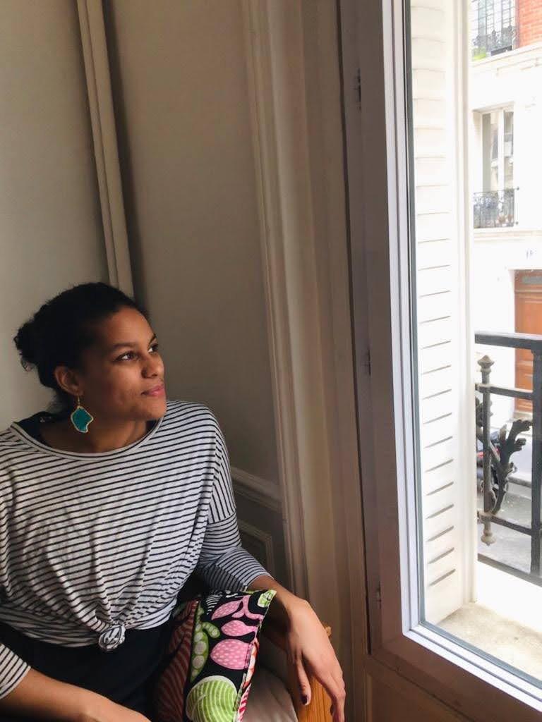 A woman looking out a window to her right