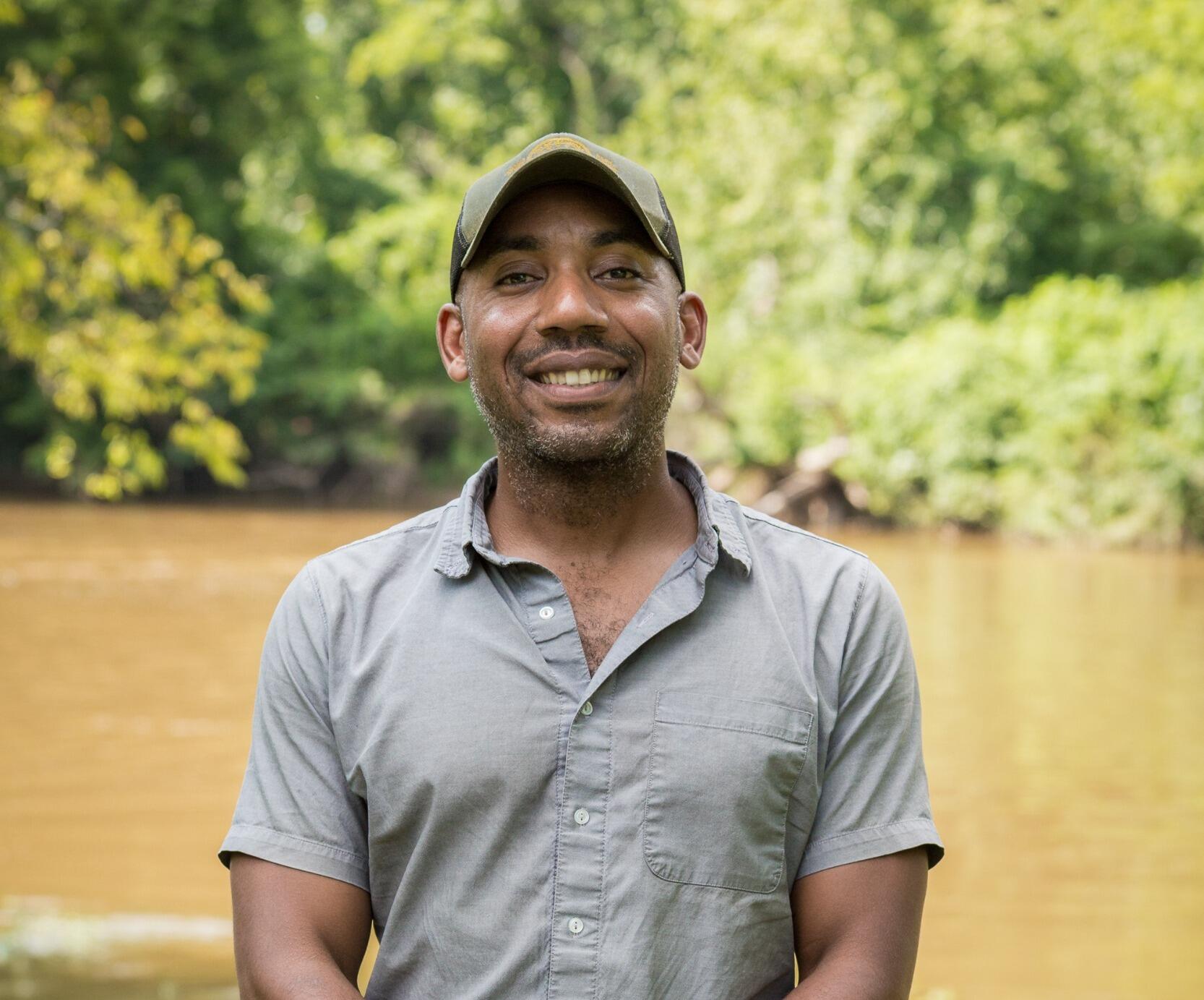 A photo of a man standing outside. 