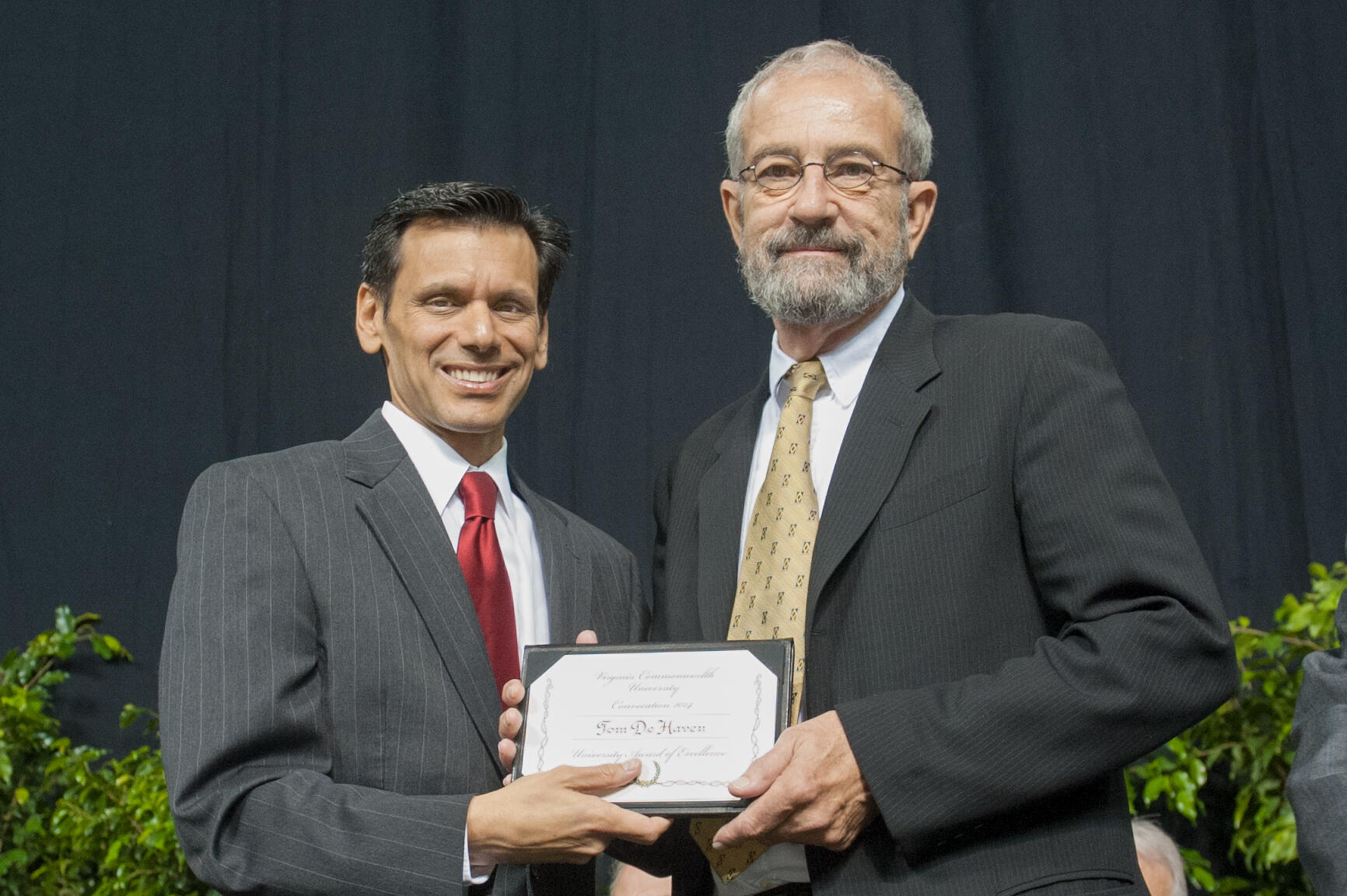 Two men holding an award plaque 