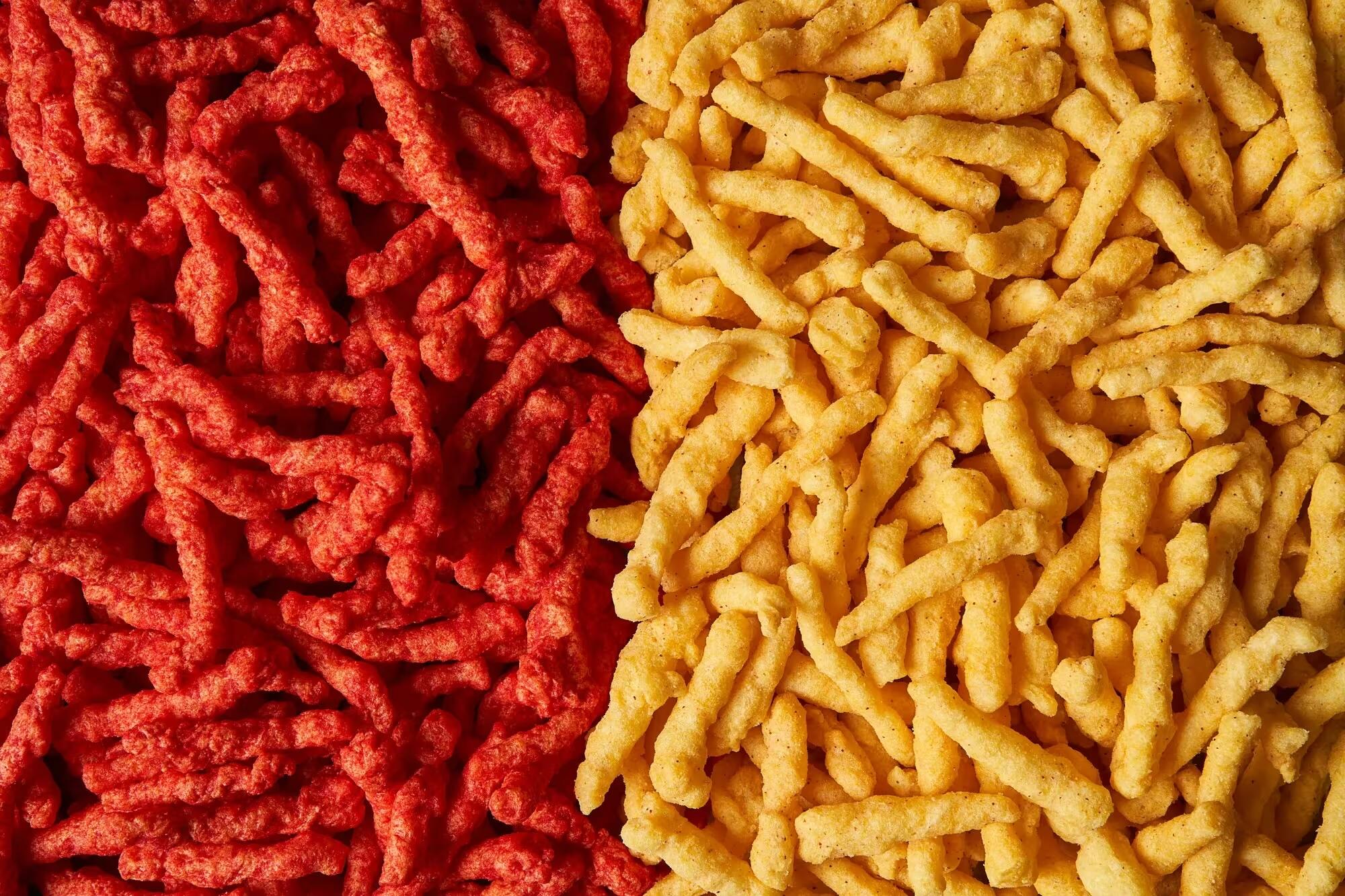 A phorto that shows two piles of Cheetos. On the left are right red colored Cheetos and on the left are light yellow Cheetos. 