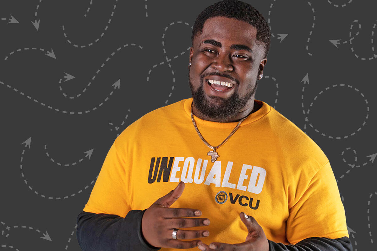 A man smiling at the camera with his arms in front of him and fists against each other 