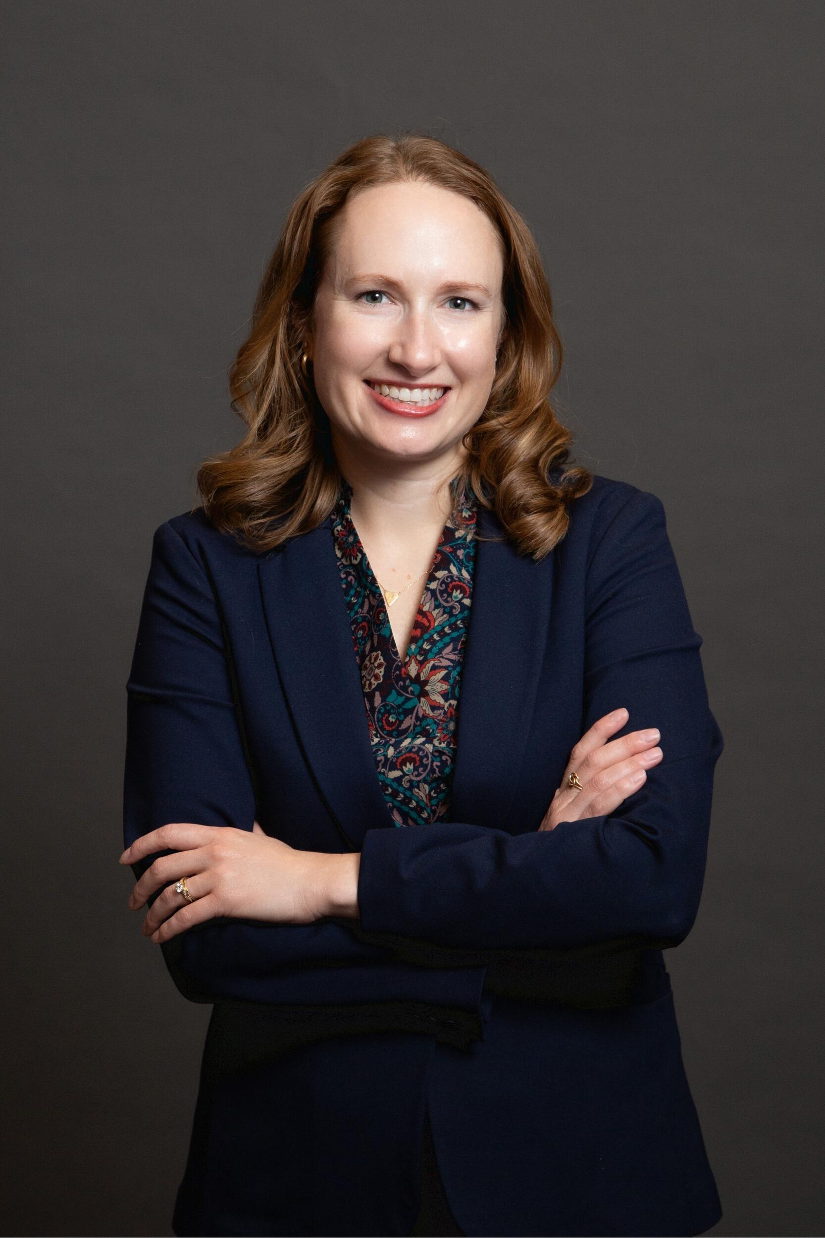 A photo of a woman with her arms crossed against her chest. 