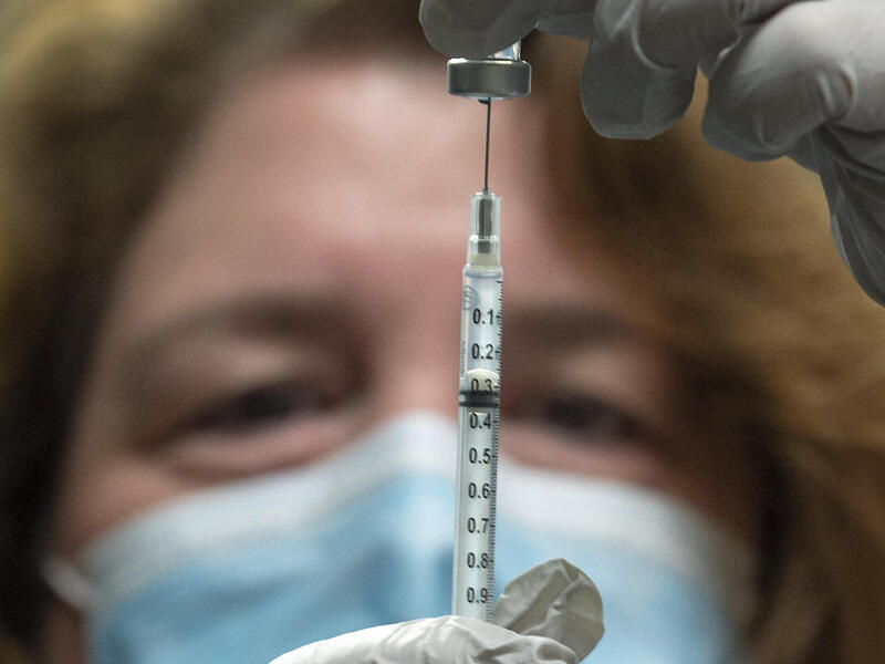 VCU Health pharmacy manager Rebeccah Collins fills a syringe with Pfizer’s COVID-19 vaccine.