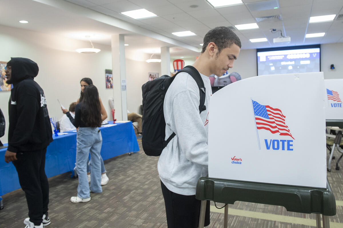 A photo of a man at a voting booth. 