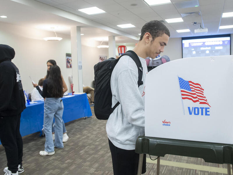 A photo of a man at a voting booth. 