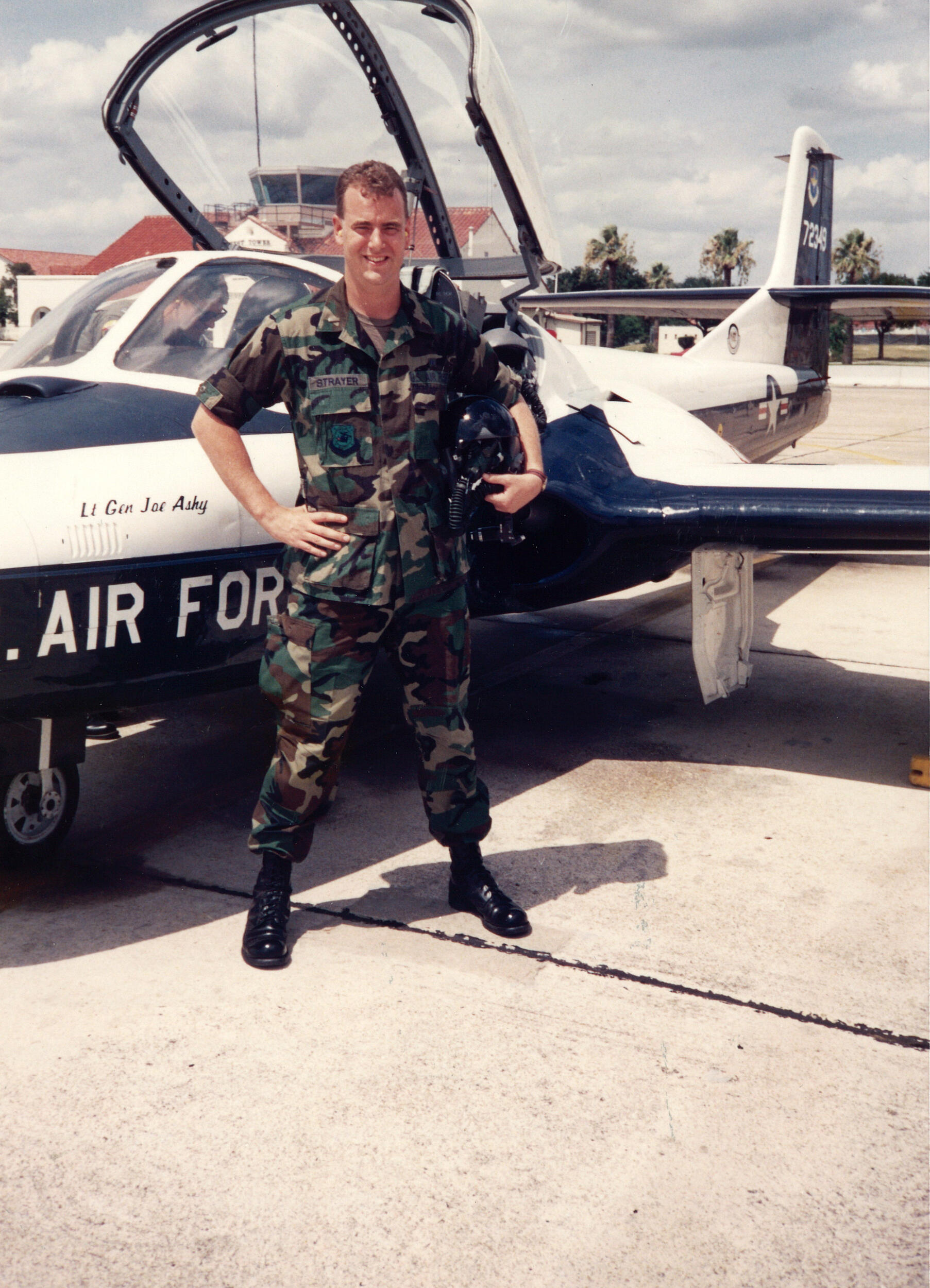 A photo of a man in a military uniform standing in front of an airplane. 