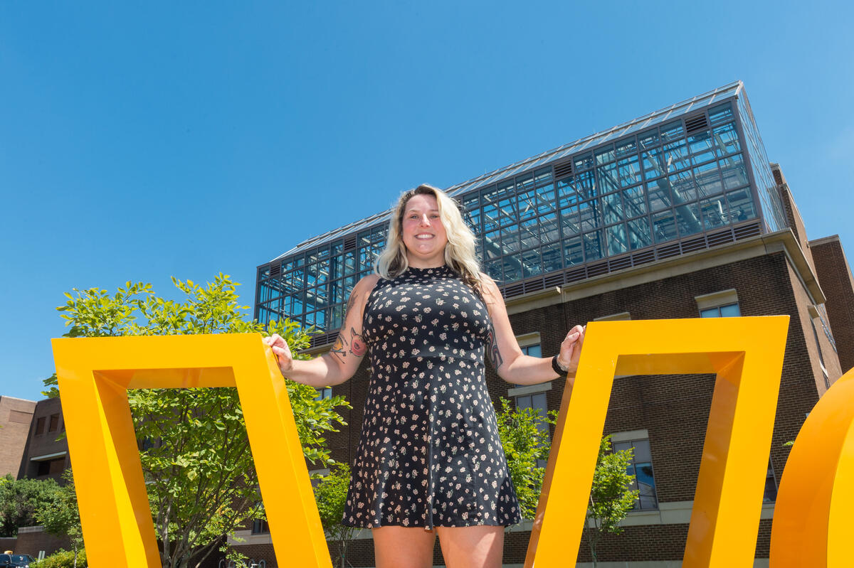 Elizabeth Dooley standing inside the letter \"v\"