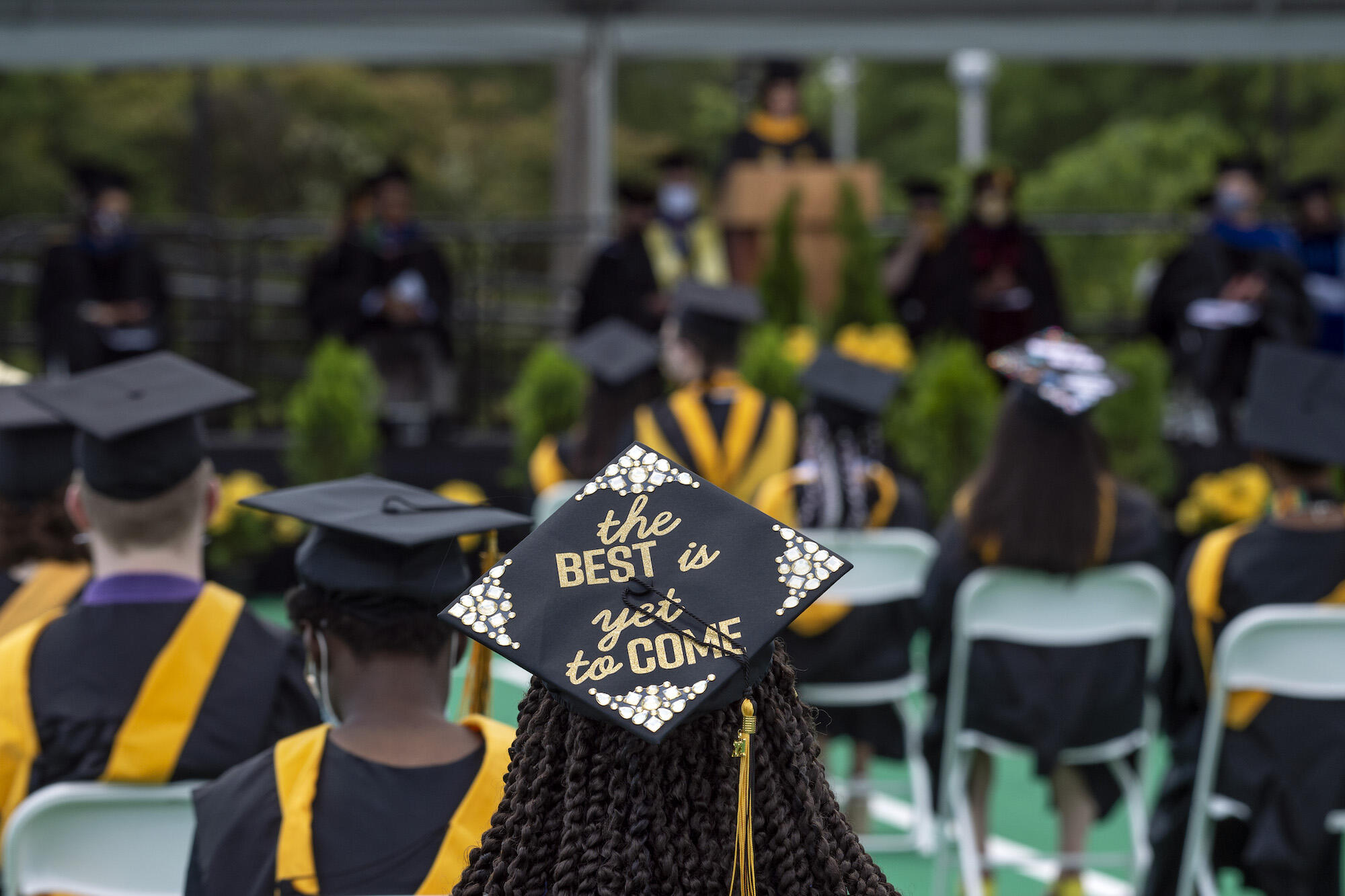 a graduate sits at a commencement ceremony