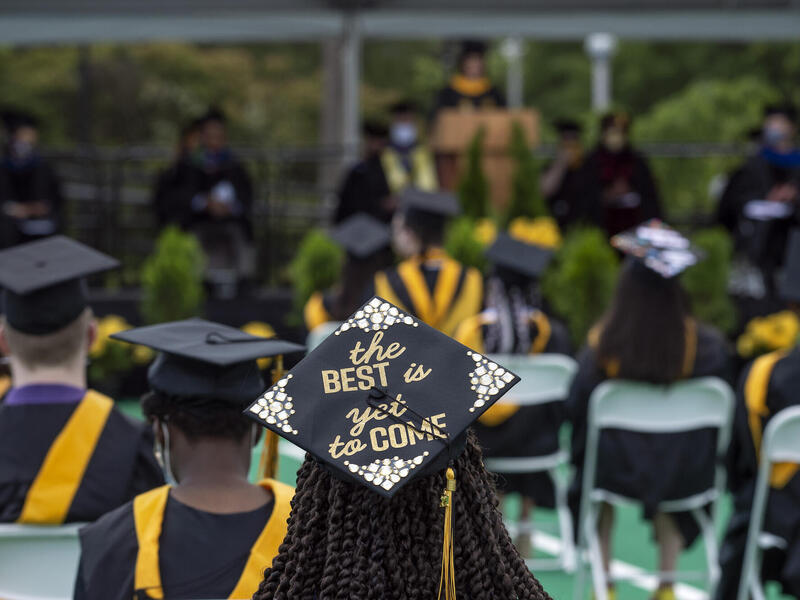 a graduate sits at a commencement ceremony