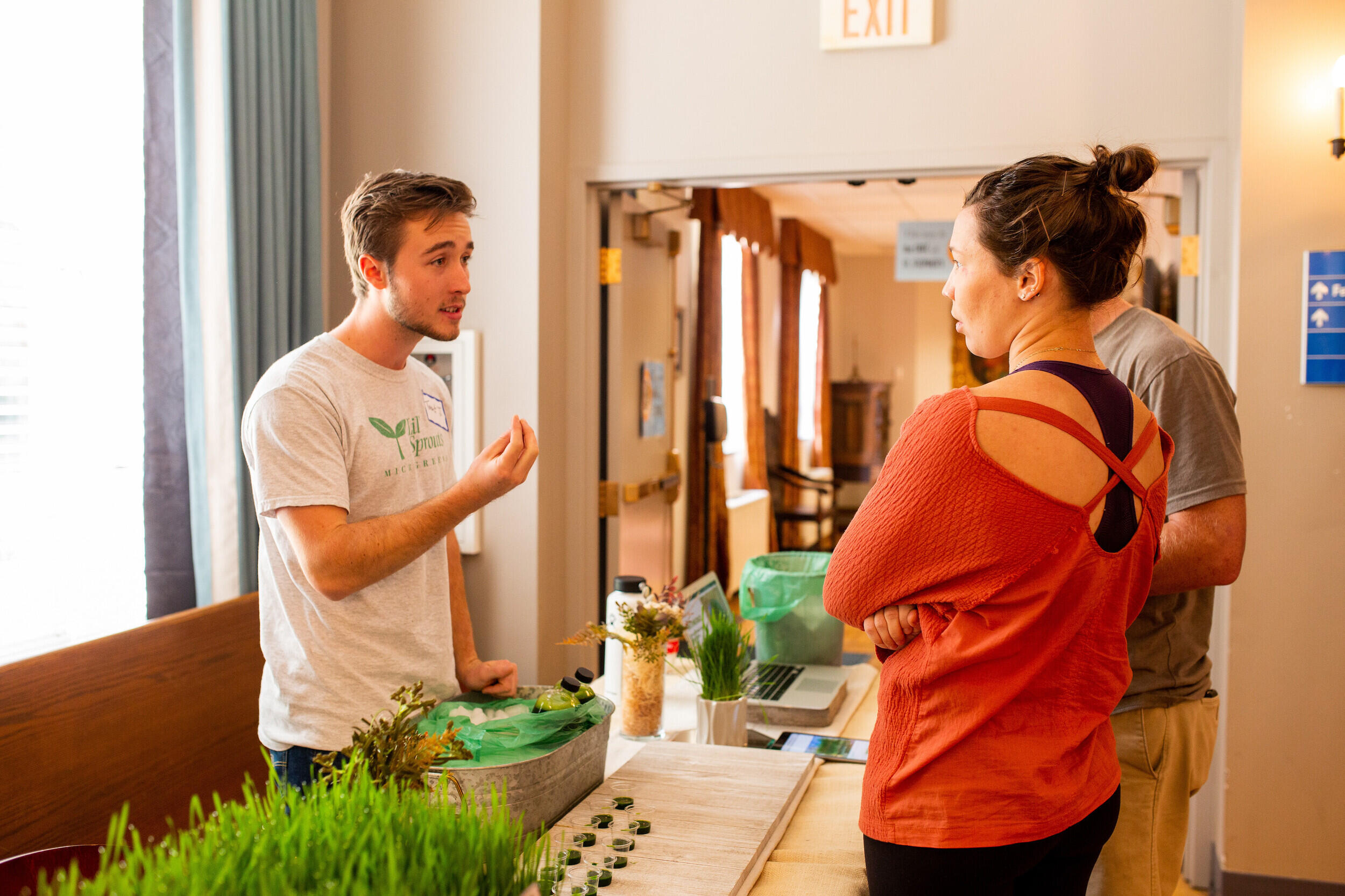 A student business owner speaks to two customers.